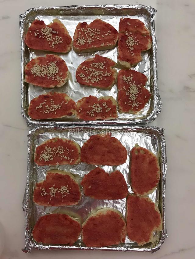 馍片涂抺腐乳完毕后，整齐摆放在刷了厚油的烤盘上面，撒上少许白芝麻。
