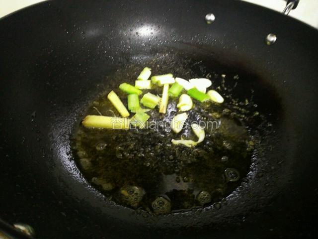 另起油锅，油比平时炒菜多一些，因为雪菜比较耗油，油热后放入葱姜蒜爆香。这里只加葱白，葱绿后面再放。