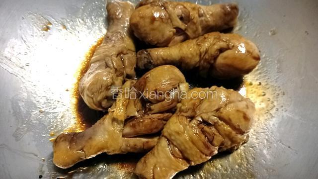 用铲子轻轻翻动鸡腿，使之上色。如图。