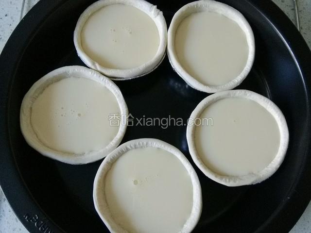 将蛋挞液，倒入，蛋挞皮中，注意不要倒得太满。