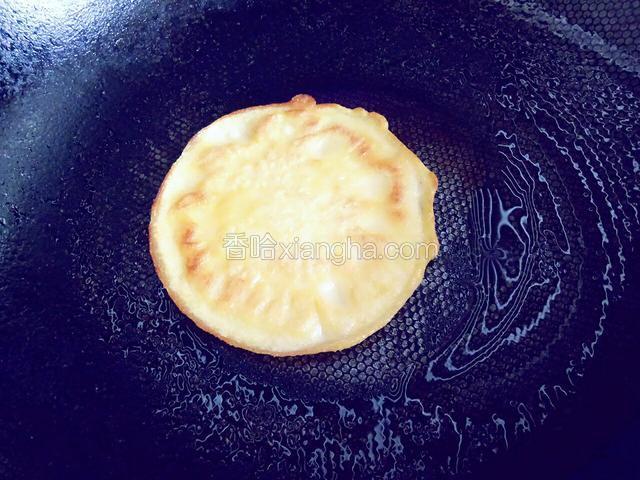 上面面糊也有凝固现象，翻面，滴几滴油，转动锅使面饼均匀受热，两面上色后盛出，同上步骤继续做完其余的面糊