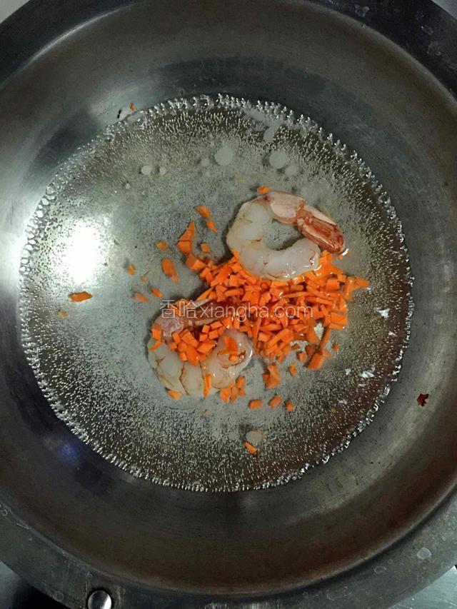 锅内加入清水，放入胡萝卜丁和虾仁煮开。
