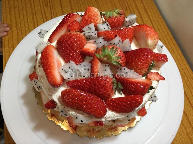 取剩下的奶油摸平蛋糕表面放上草莓和少许火龙果丁装饰下