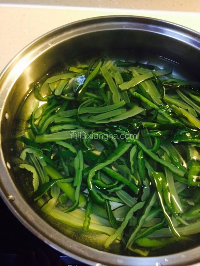 锅中清水做开，倒入裙带菜丝焯水，不用煮开，烫一下就捞起