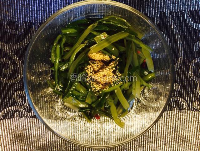 从冰箱里取出冷藏后的裙带菜，加入香醋，糖，辣椒油拌匀，撒上芝麻