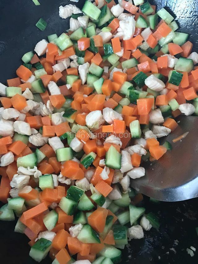 快速翻炒，鸡胸肉丁变白后，加入胡萝卜丁翻炒。