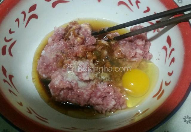 肉糜中加入一点点豆油，再放十三香、盐、白糖、生抽、蒸鱼豉油、姜汁水，打一个鸡蛋顺时针方向搅拌。