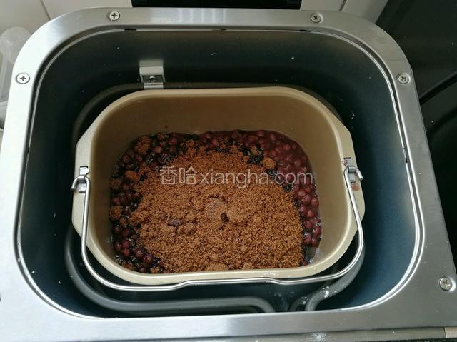 把煮好的红豆倒入面包机桶，倒入红糖。