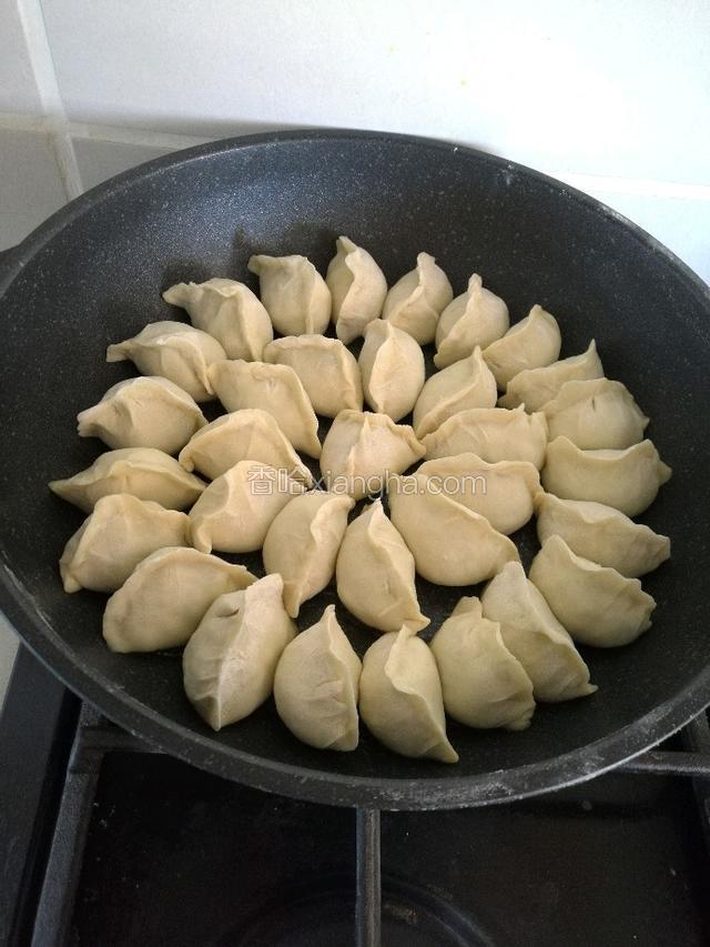 煎锅里倒入少量油把锅贴摆好，煎2分钟，倒入开水，漫过锅贴1/3的位置。盖盖。小火。煎4分钟。