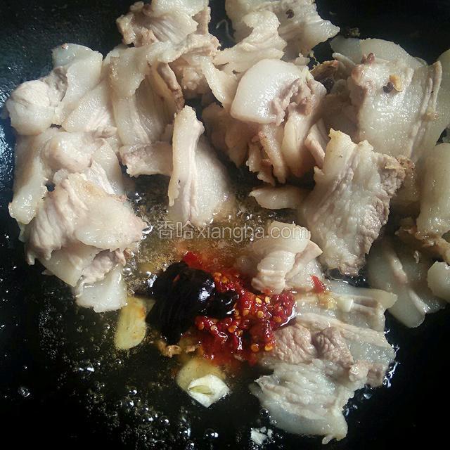 慢火煸得肉开始卷曲，下姜蒜碎，炒香后，下豆瓣，豆豉甜面酱煸炒，追求正宗者选郫县豆瓣，重庆永川豆豉。炒香后加适量白酒，比料酒香