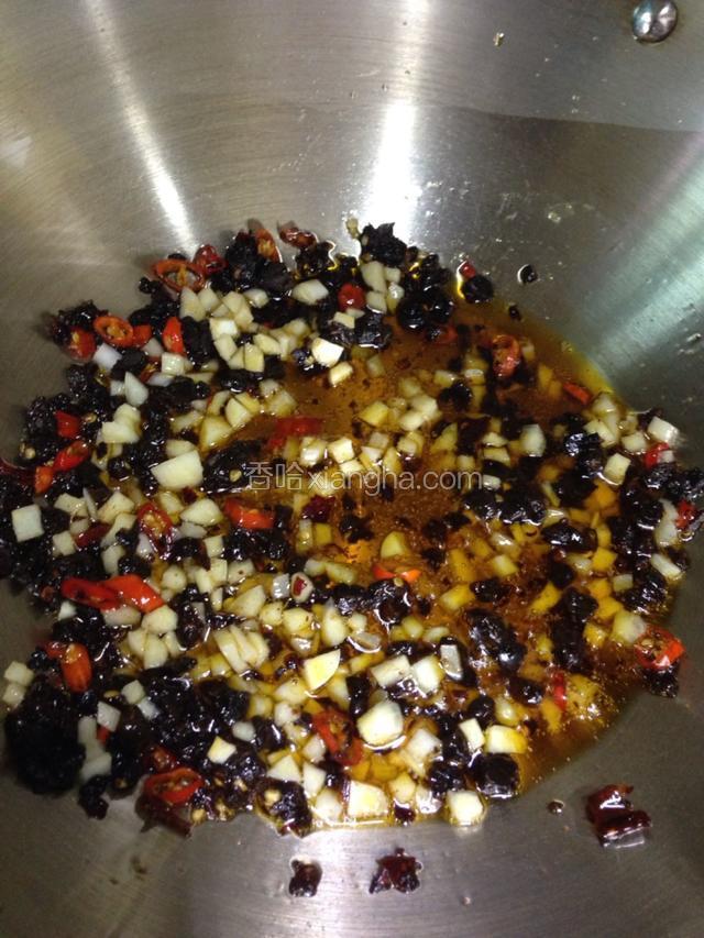 继续小火放入剁好的豆鼓和蒜粒，炒出香味且蒜粒微微泛黄。稍微加一勺水或者煮猪肚的汤煮开。