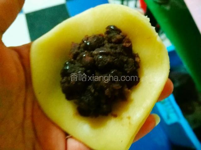 将豆沙馅放入面皮中
