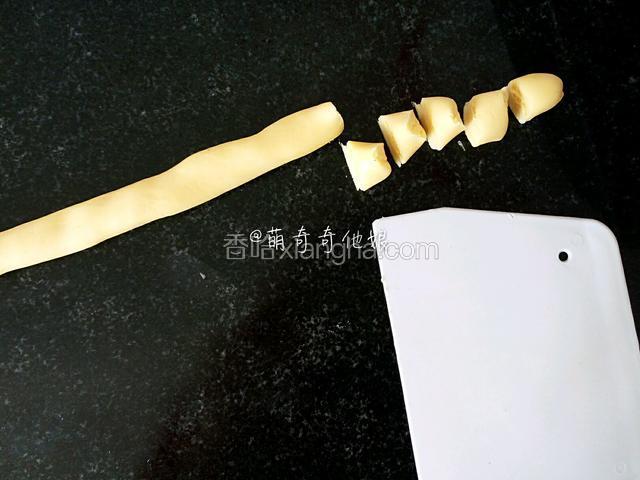 松弛好后用刮板切“米”字，成八份，然后取其中一份搓成细长条，用刮板切成一个个小段，再分别搓圆即可，搓的时候也要随时覆盖保鲜膜，不然风干了也不好搓圆。
其他七份还不用要用保鲜膜或保鲜袋密封着以免风干。
搓的时候如果出现面团比较干了可以手指沾点牛奶捏几下面团，让面团滋润一下再操作。
搓好的放烤盘上也要记得盖保鲜膜以免风干。