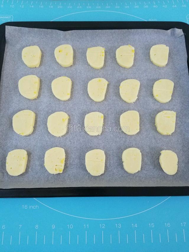 一个半小时后从冰箱取出冷冻的面团，用刀切成均匀厚度的薄片。