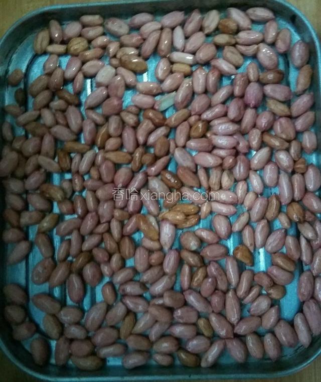 把花生米放入烤盘上，抖一下烤盘，使花生米平铺在烤盘上。