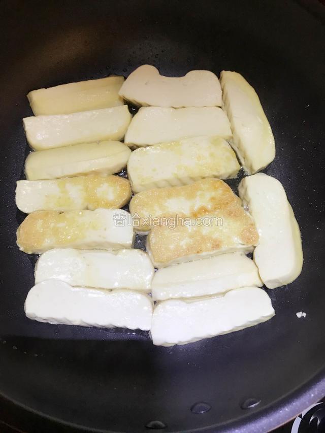 大概几分钟后，用筷子或者木铲碰触一下豆干底部，触感稍硬便可轻松翻面再继续煎至两面金黄即可。