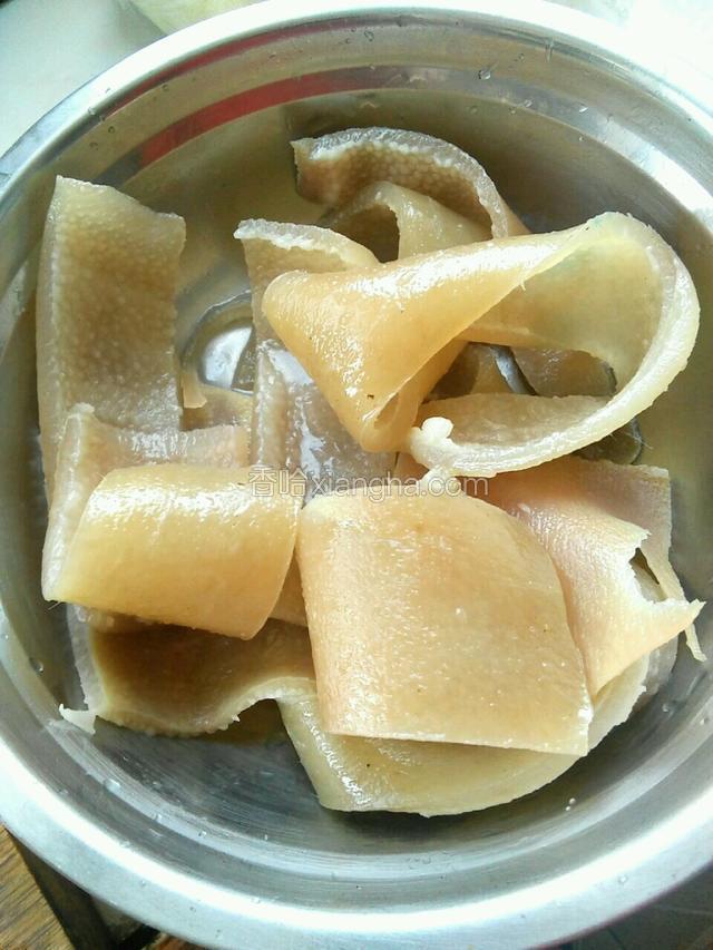 把肉皮用水煮一下变软，捞出除去多余的油质去掉表皮毛茬，
