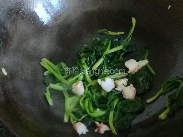 热油下锅煸炒菠菜，加适量盐加入虾仁。
