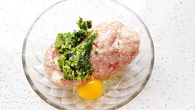 肉末放入玻璃碗中，加入葱姜末，打入一个鸡蛋。