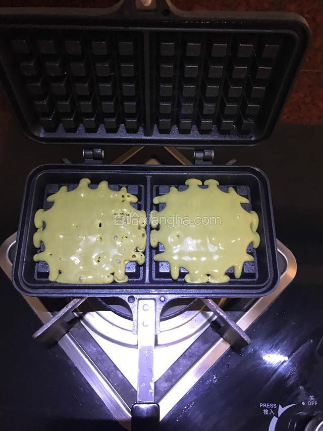 加热至滴水嗞声便可以舀入面糊，转小火，从中间开始倒，慢慢填满，合上盖子。我比较喜欢不满的样式，所以没有倒满。