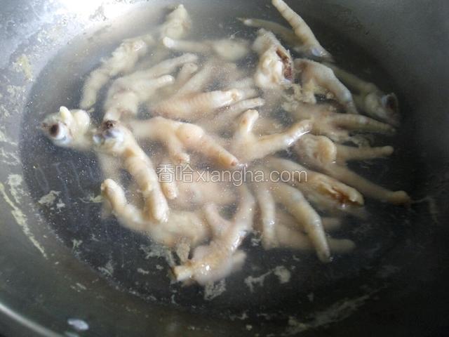 锅内放入适量的水，放入两片姜，放一勺料酒，在把切好的鸡爪放入锅中焯水