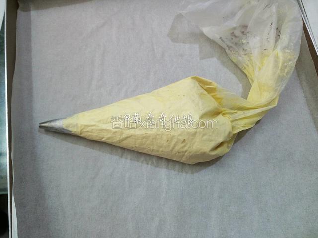 烤盘提前铺好油纸，裱花袋剪个小口子装入圆形花嘴，把拌好的面糊装进入。
