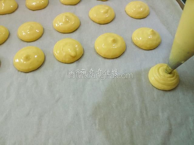 在烤盘上有间隔地挤一个个圆形。