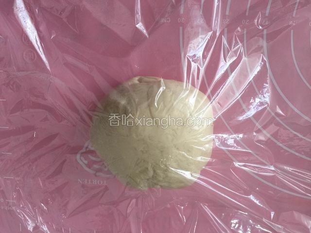 然后取出按压折叠排气，再次滚圆覆盖保鲜膜松弛15分钟。
