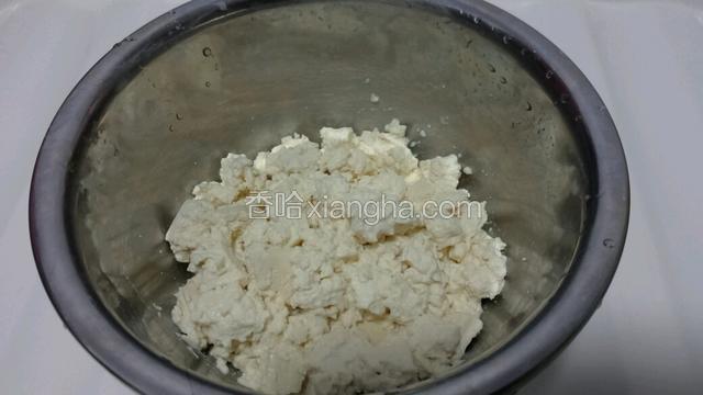 把豆腐放入盆中，用筷子搅碎。