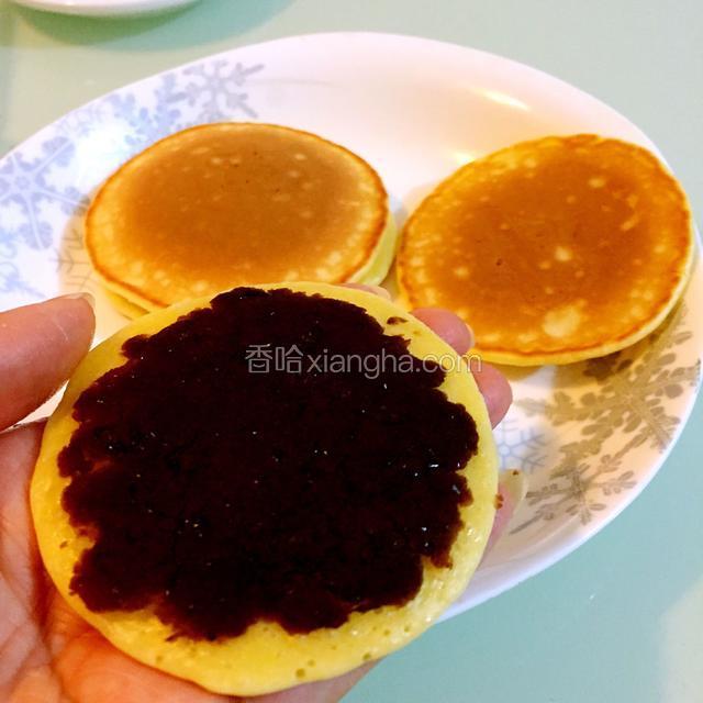 取一只饼，反面抹上豆沙或果酱。