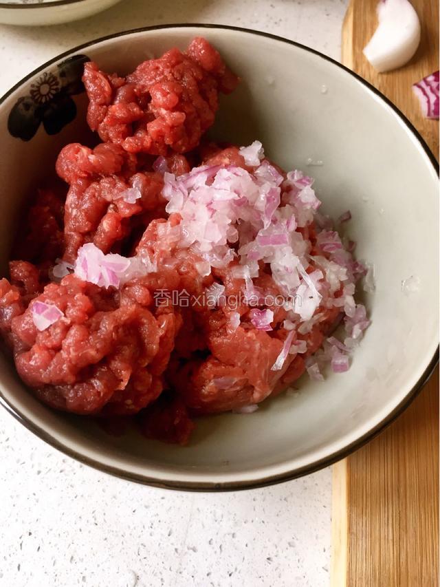 这次做牛肉汉堡做的主料是牛里脊，搅成肉糜状，先将洋葱切成小粒状，倒入肉糜里搅拌均匀，加点料酒
