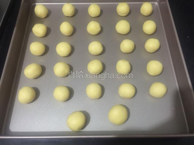 取出冷藏好的面团，分成同样大小的小面团，搓圆排入烤盘里。