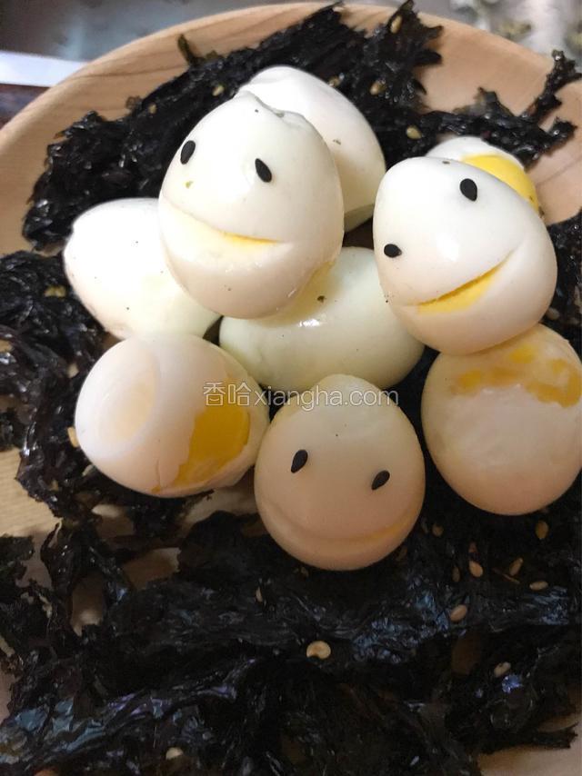 再安上两颗黑芝麻在左右两边，变成眼睛。就这样，一只可爱又萌萌哒的小蛋蛋就出现了，再堆放在海苔上，就是一窝快乐的蛋了。