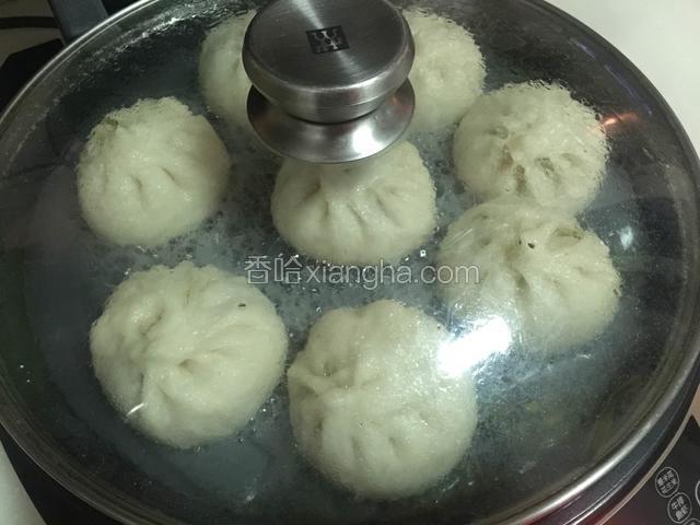电饼铛预热后，放少许玉米油，把包子摆放好，倒入清水至包子一半的高度，盖好盖子，中火加热，至水干即可。