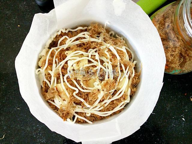 直至面包块全部铺完，最上面一层在撒上肉松后再挤一圈沙拉酱。
我这里沙拉酱是我家小盆友挤的，有点多，你们就围着挤一圈即可。