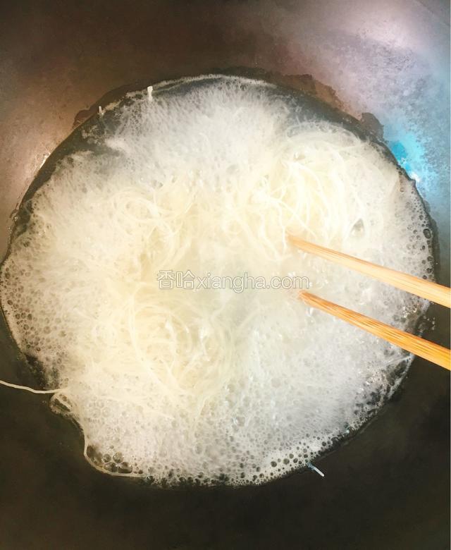 煮一分钟左右后用筷子将粉丝饼打散，使粉饼受热均匀、以防打结。
