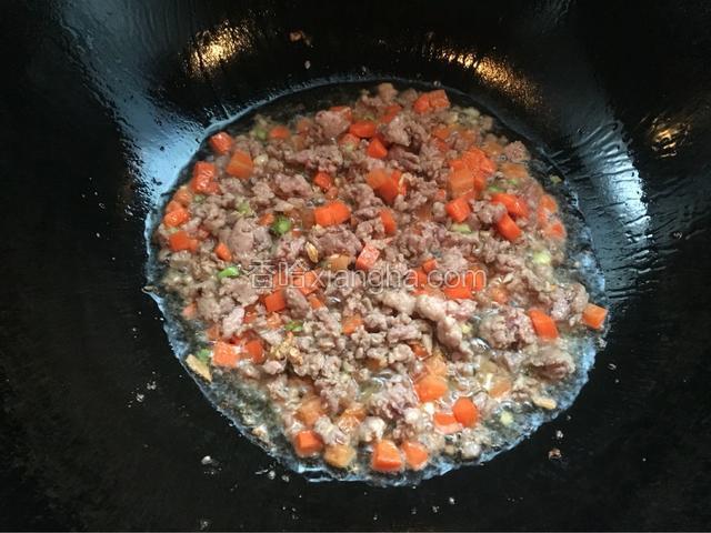 接着放入肉末和红萝卜炒至断生。