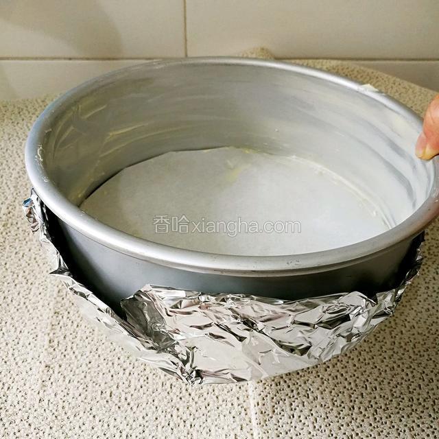 然后再这个活底膜的外面包上一层锡箔纸。我们要用水浴法来烤这块蛋糕，到时候怕烤的时候液体漏出来。所以包上一层锡箔纸。
这里我要啰嗦两句就是，可以用固体模来烤。但是建议新手不要这样尝试。因为用固体模具的话，到时候脱模就比较麻烦。