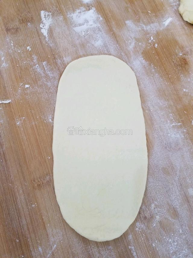 取一个小面团按扁，擀成牛舌状。