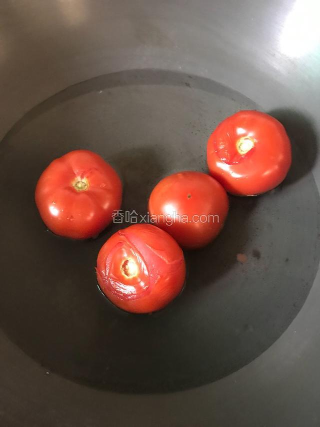 这个时候先把番茄烫水去皮。可以直接冷水下，多翻面，一旦皮皱就可以拿出来了，小心别把番茄煮熟了。过程也就一两分钟。
