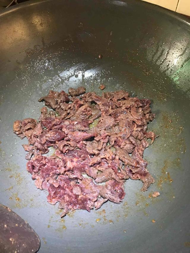 倒入腌好的牛肉翻炒至变色。