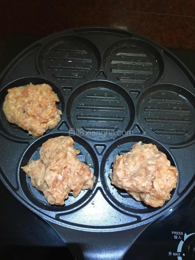 中火下油烧热煎锅，用汤匙舀入肉馅。