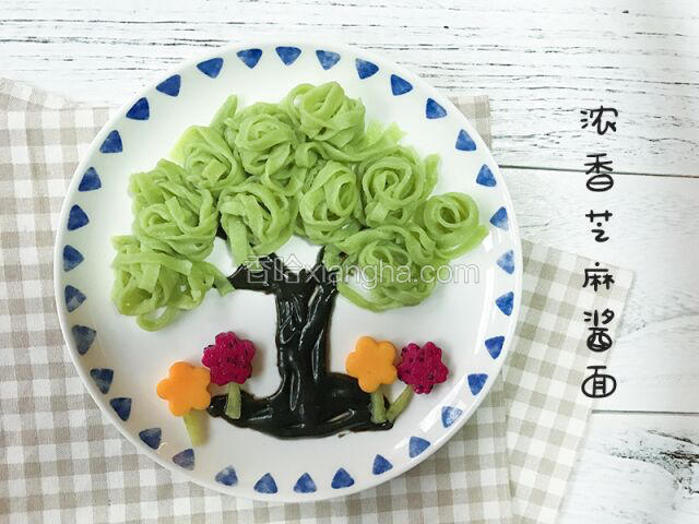 在盘子中用芝麻酱做成树干，菠菜面条做成树冠，还可以用水果装饰这道菜不用劝，孩子会迫不及待的吃光光，而且晒朋友圈~~ 你懂得 ( • ̀ω•́ )