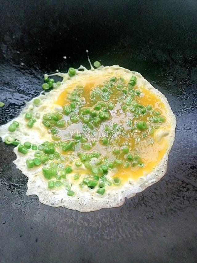 两三分钟之后倒入鸡蛋包围着豆角