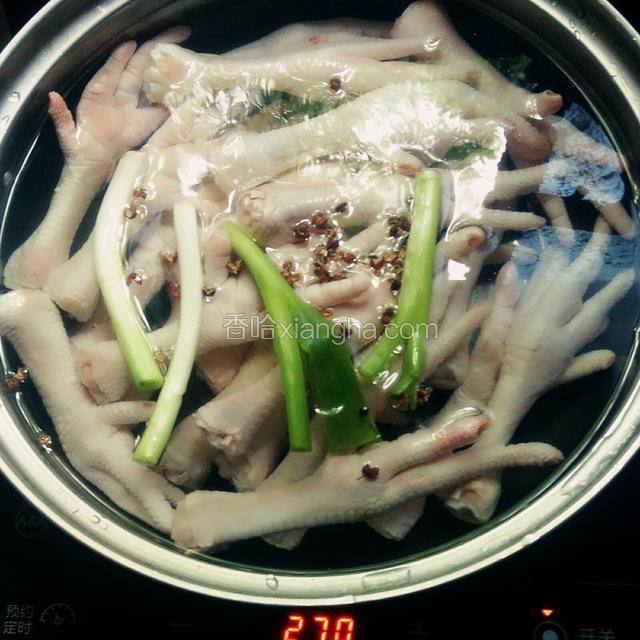 将鸡爪放入锅中，放一勺料酒、葱段、花椒，大火煮开后加盖小火煮十分钟