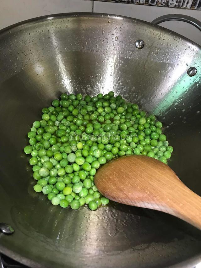 锅内放入适量的油，油温热后放入豌豆翻炒一会儿