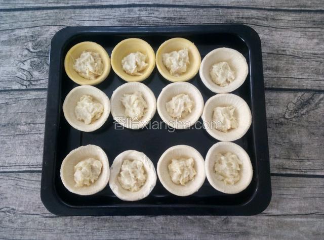 把适量的榴莲泥放入蛋挞皮中。
