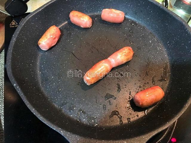 热狗提前放入平底锅煎至表面微焦
