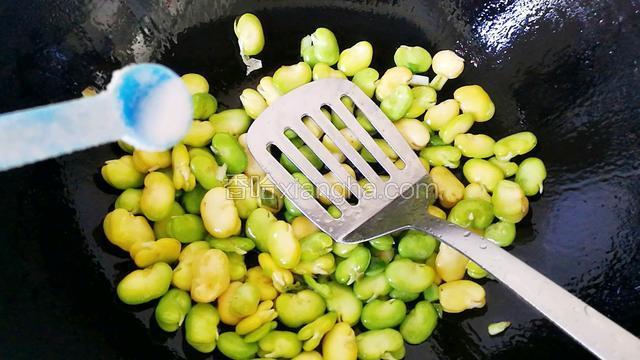 倒入蚕豆加少许盐，煸炒几下。