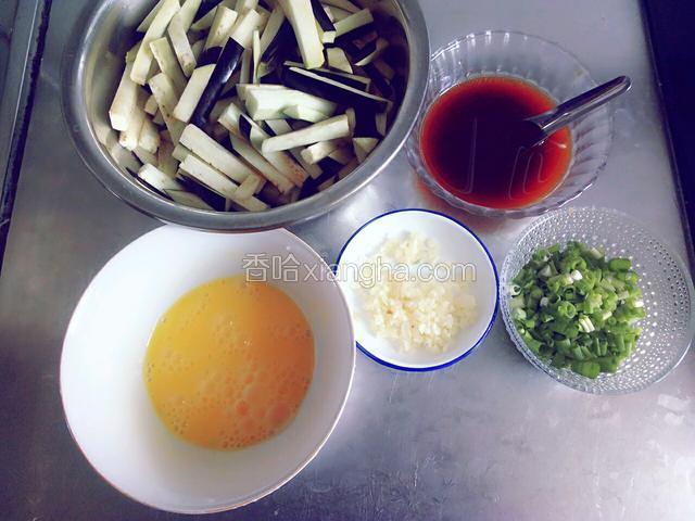 准备食材:茄子切成条，蒜和小葱切末，鸡蛋划散，调好料汁